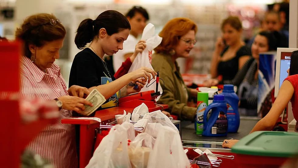 Shoppers paying at a supermarket checkout counter