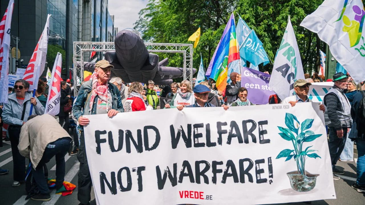 Demonstrators in Brussels carry a banner reading Fund Welfare Not Warfare at a protest against rising defence spending