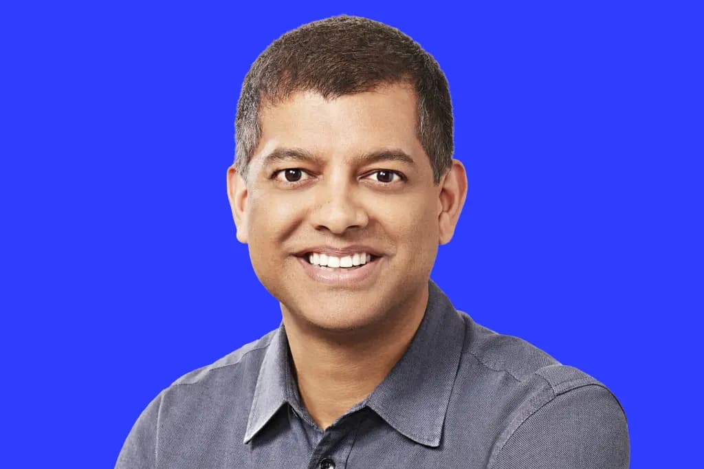 Krishna Rao smiles in a headshot against a solid blue background