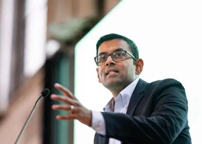 Arvind Narayanan gestures while speaking at a podium