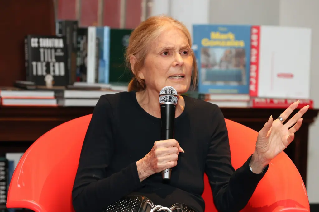 Gloria Steinem speaks into a microphone during a public event