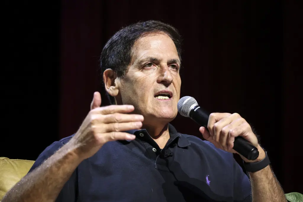 Mark Cuban speaks into a microphone while gesturing during an interview