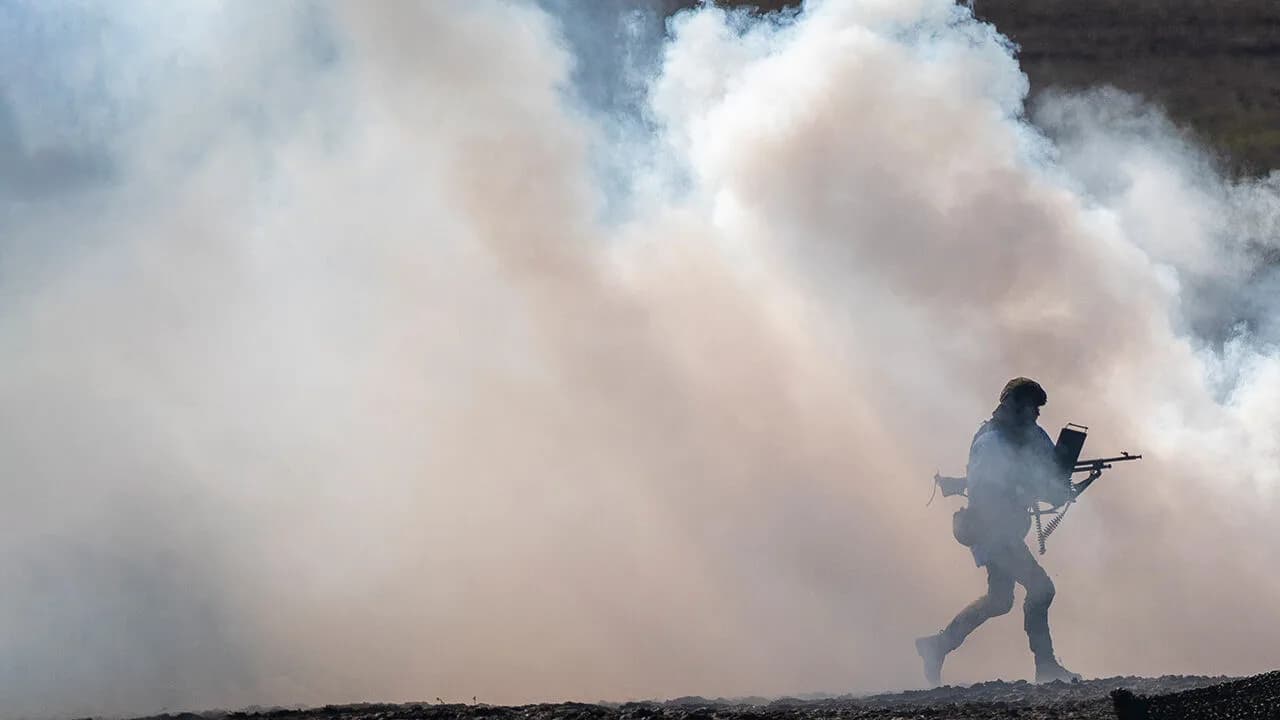 A soldier moves through smoke during a live fire exercise on NATO's eastern flank
