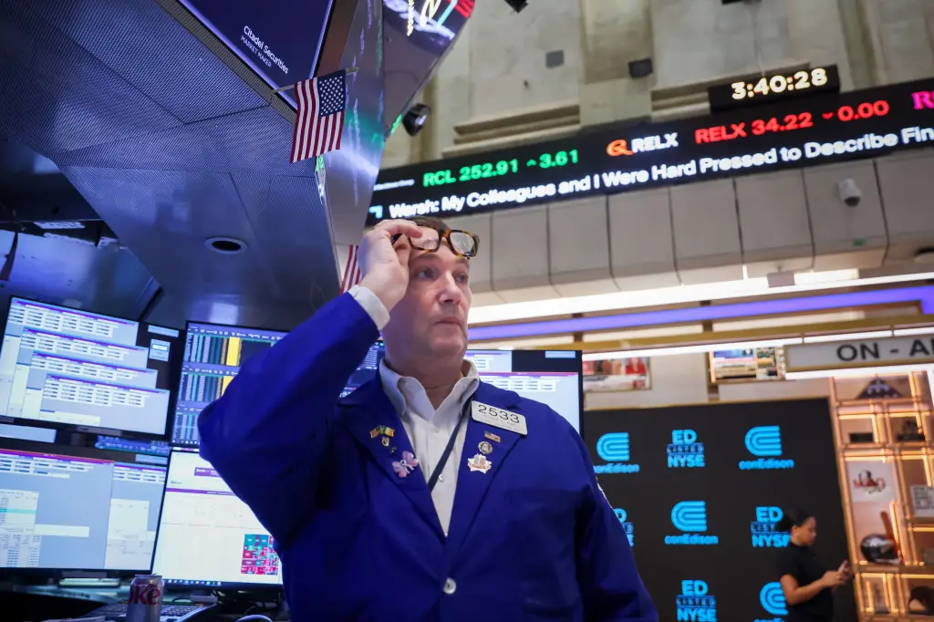 A trader looks up at screens on the floor of the New York Stock Exchange