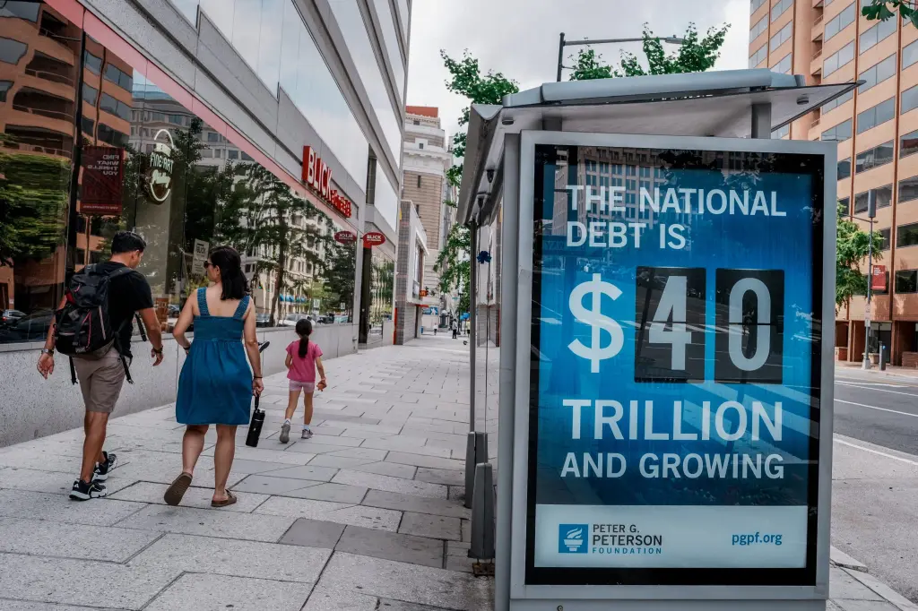 A digital sign reads the national debt is 40 trillion dollars and growing, at a bus stop in Washington DC