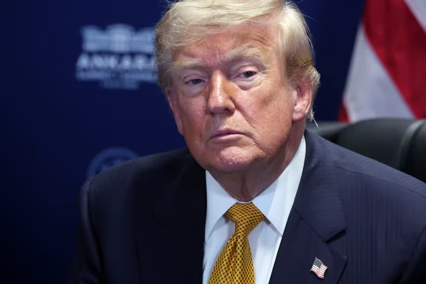 US President Donald Trump listens during a meeting, an American flag behind him