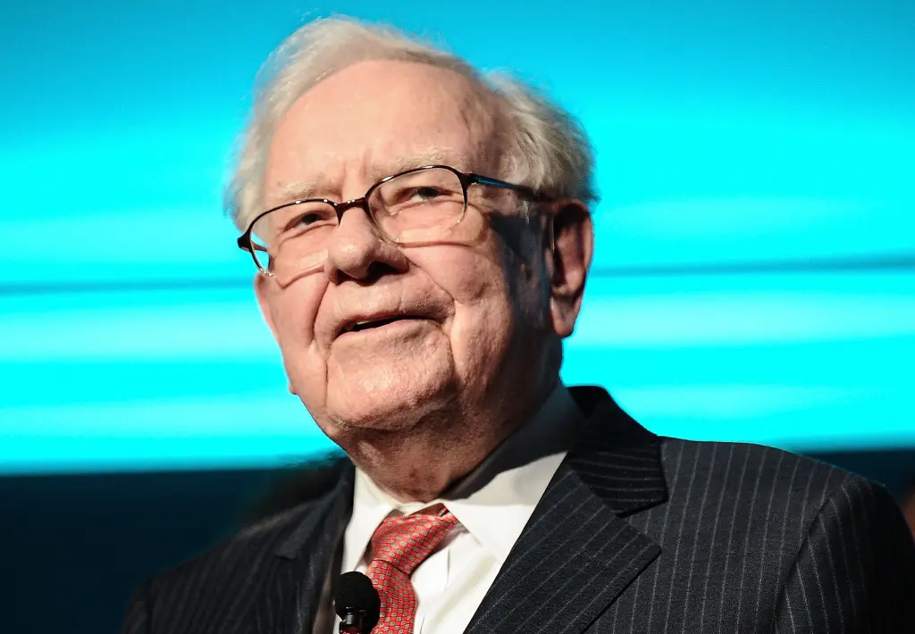 Warren Buffett speaks into a microphone on stage
